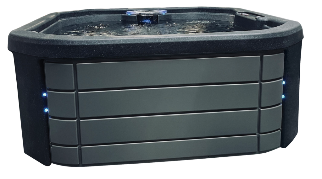 A closed hot tub from the InnovaSpa Orion Series with a black and gray color. The hot tub has a rounded shape with angular corners, featuring a built-in storage compartment with curved panels on one side. The surface appears smooth and sturdy.